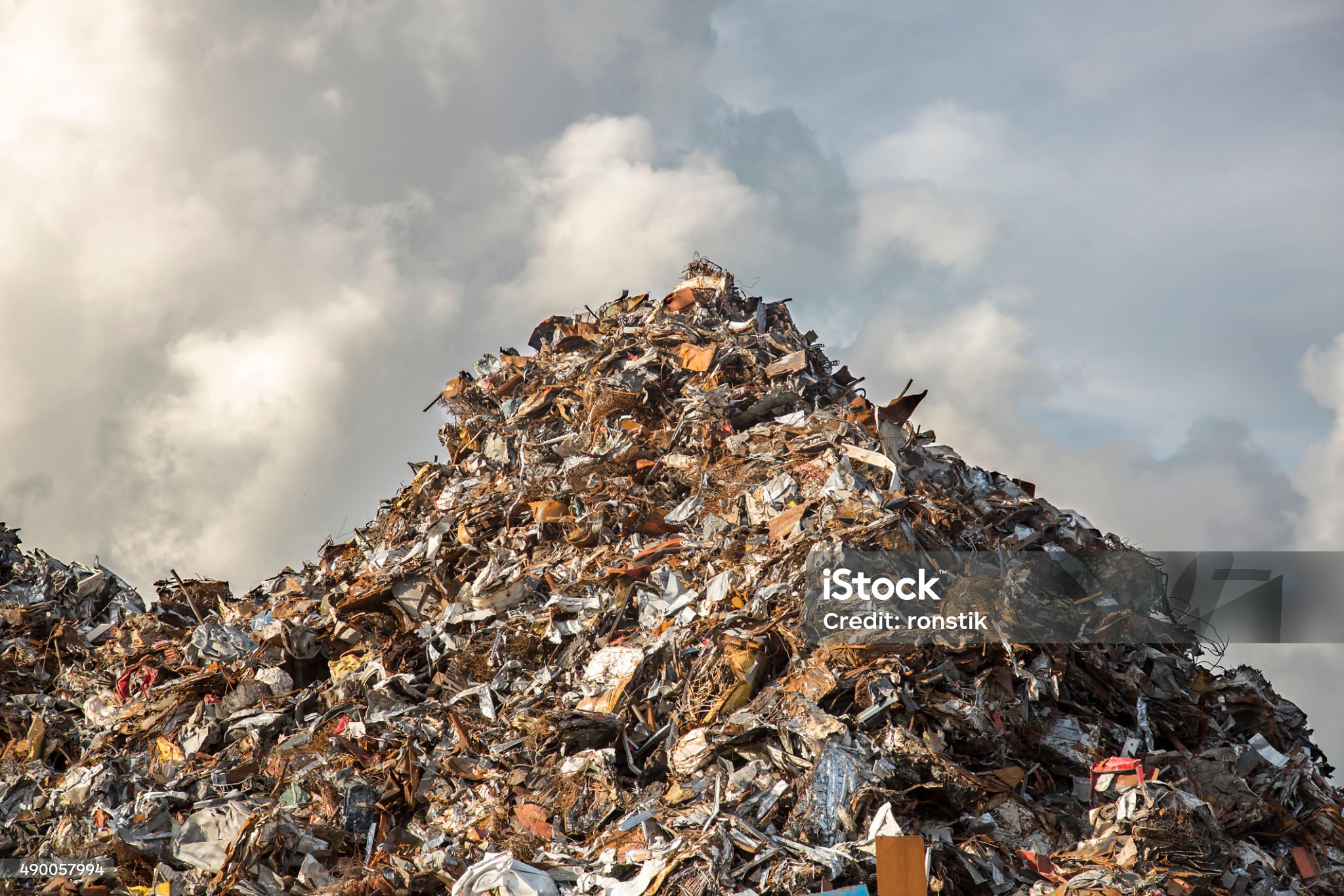 heap of scrap iron against dramatic cloudy sky