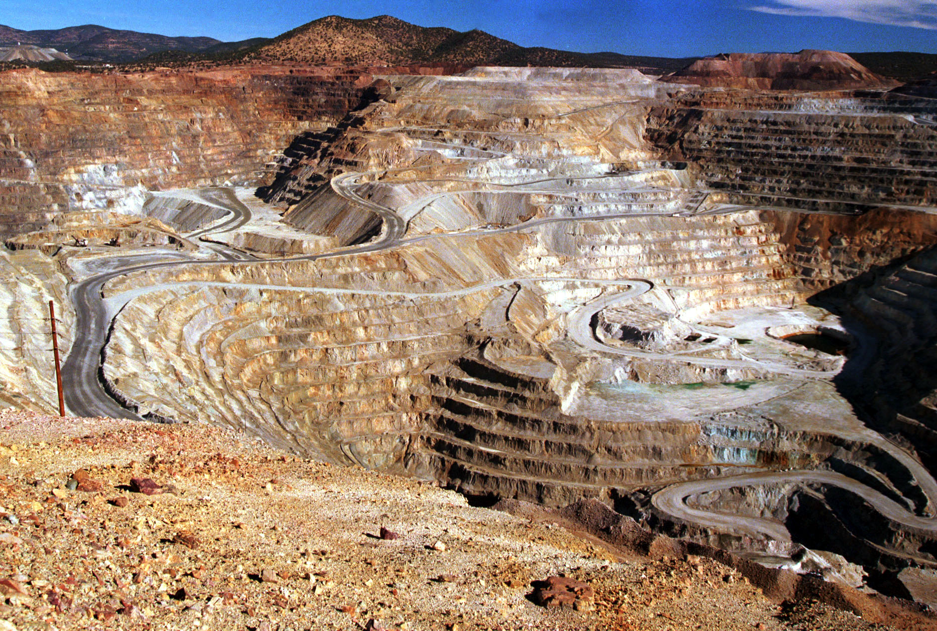 Feature Story:(6 Of 11) Trucks Carry The Raw Material To Be Made Into Copper Out Of One Of The Oldest And Largest Open-Pit Mines In North America Owned By Phelps Dodge Mining Co June 30,1999. It Is Located Just East Of Silver City, New Mexico. Formally Called Chino Mining Company, It Is Referred To Locally As The Santa Rita Mine Because It Once Housed A Company Town That Was Demolished In The 1960's To Expand The Pit. Phelps Dodge Mining Company Announces More Layoffs. The Company Has Already Had Several Closures And Layoffs Due To The Falling Prices Of Copper. The Closures Have Affected Their Mining Operations In The Silver City Region Of New Mexico, As Well As, The Latest In El Paso, Texas.  (Photo By Joe Raedle/Getty Images)